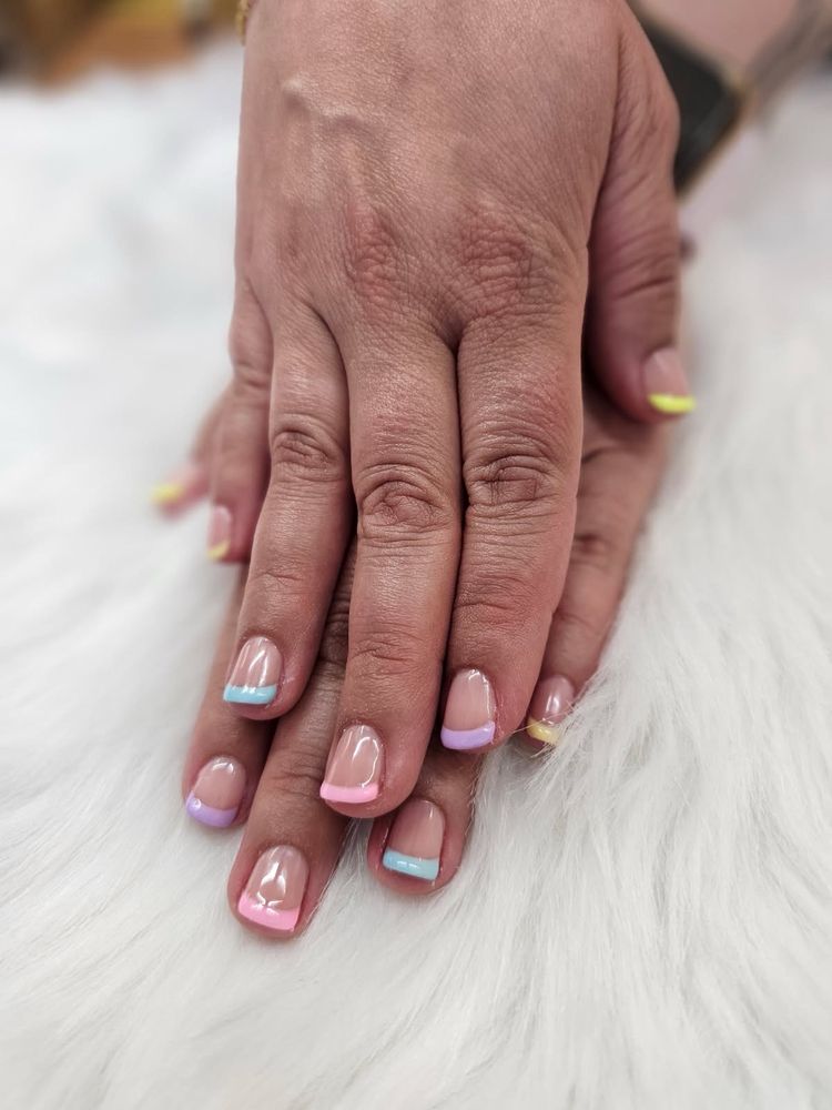 Pastel French tips in pink, lavender, blue, and yellow on natural nails